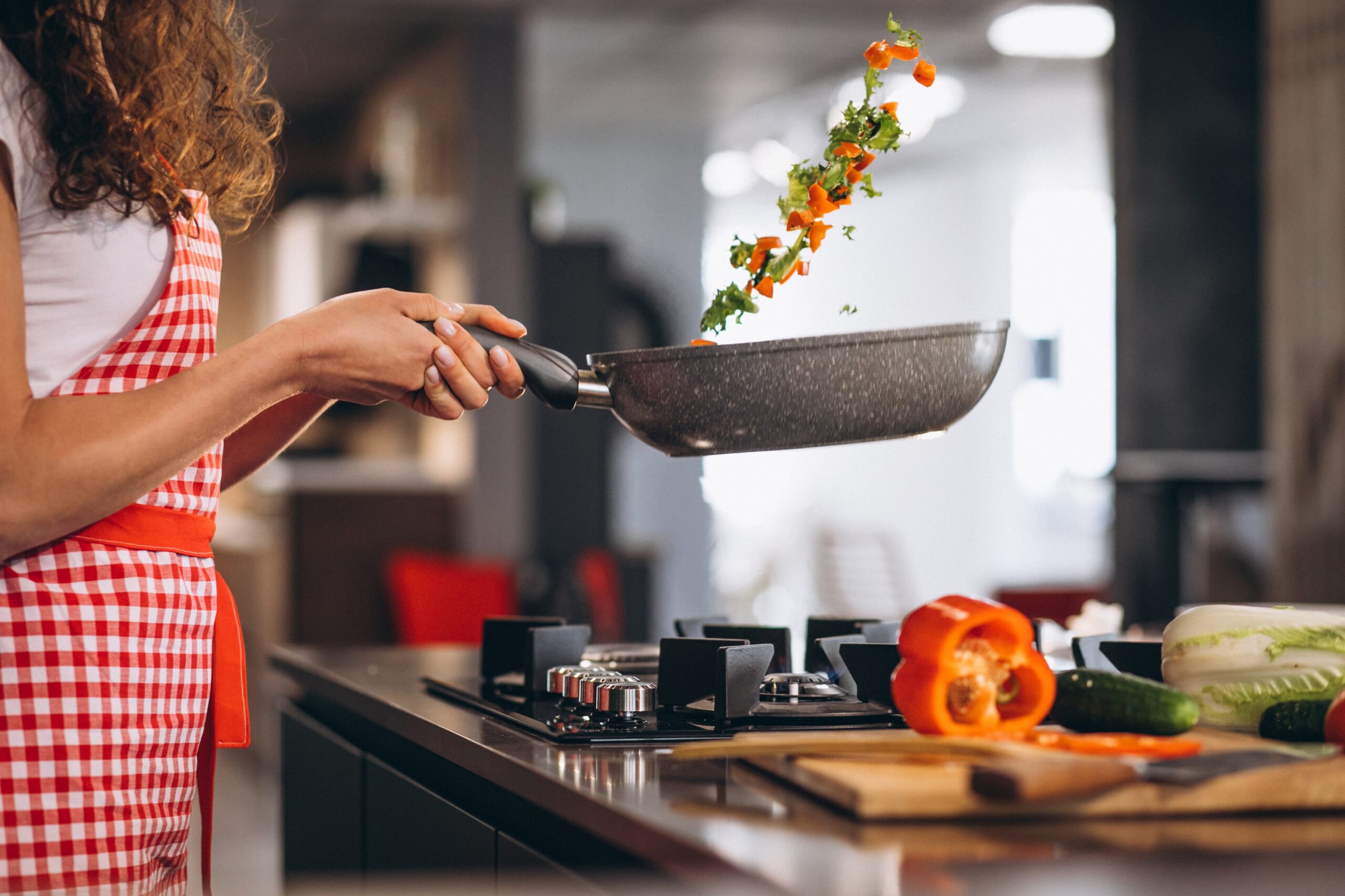 woman-chef-cooking-vegetables-pan-min